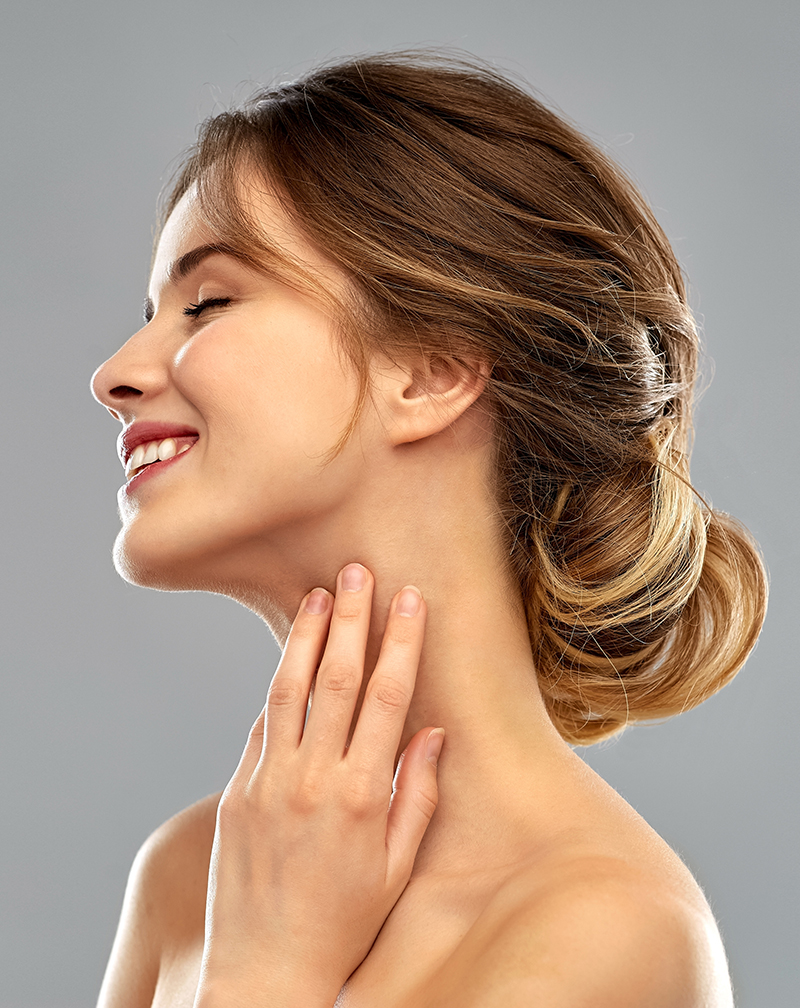 smiling young woman touching her neck