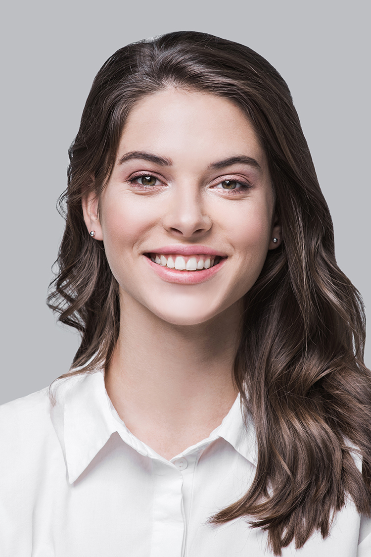 Portrait of a beautiful young woman posing against a grey background
